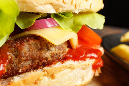 Tasty burger close-up. Burger with tomatoes, greens, onions and meat.の写真素材