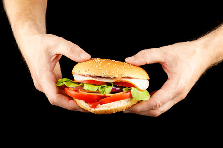 Burger in hands isolate on black.の写真素材