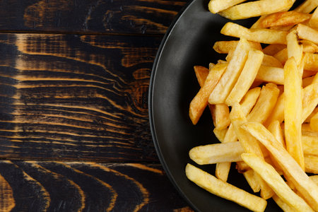 French fries in a black plate on the table. Appetizing fried potatoes. place for text cope spaceの写真素材
