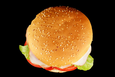 burger with lettuce, tomato, cheese and cutlet top view. Classic cheeseburger with beef, cheese, tomato on black background. top view.の写真素材