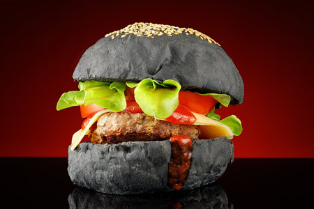 Black burger homemade. Juicy black burger on a beautiful backgroundの写真素材