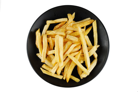 French fries in a black plate isolate. Appetizing fried potatoes.の写真素材