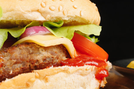 Tasty burger close-up. home made beef burger with tomato, cheese, beef and salad.の写真素材