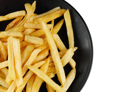 French fries in a black plate isolate. Appetizing fried potatoes. place for text cope spaceの写真素材