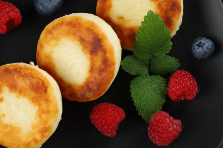 Cottage cheese fritters in a plate with berries.の写真素材