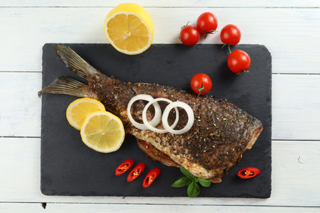Fried carp fish on the table. Baked fish with vegetablesの写真素材