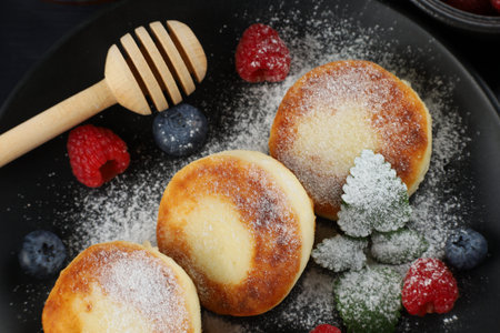 Cottage cheese fritters in a plate with berries.の写真素材
