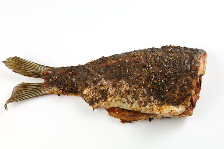 Grilled fish on the table. Baked carp isolated on white.の写真素材