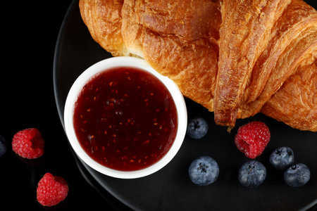 Croissant with jam and berries. traditional breakfast.の写真素材