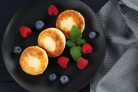 curd fritter with berries in a plate. cottage cheese fritters.の写真素材
