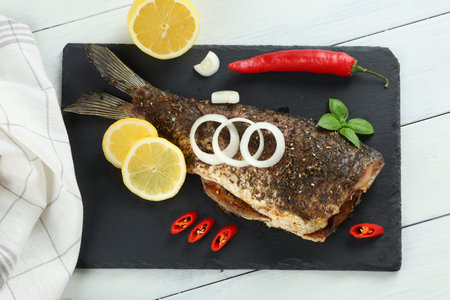 Fried carp fish with vegetables, tomatoes and lemon. Grilled fish carp servedの写真素材