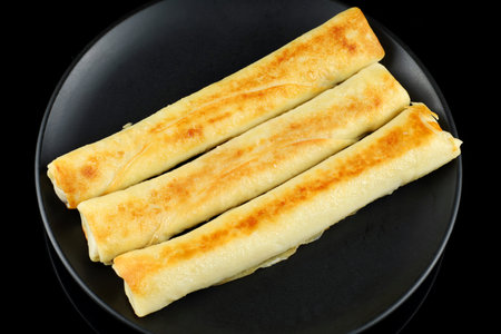 Pancake rolls on a black plate. Stuffed thin pancakes rolledの写真素材