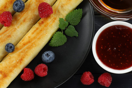 Pancakes rolls with raspberries and blueberries. Traditional breakfast and food.の写真素材