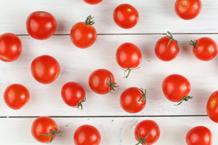 Red cherry tomatoes on a white table. Background or texture with tomatoesの写真素材