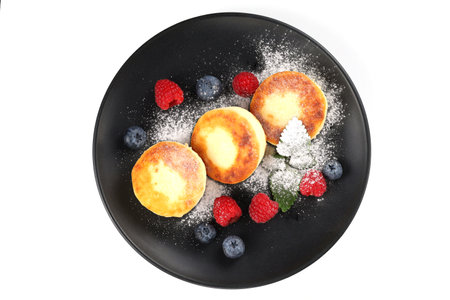 Cottage cheese fritters in a plate with berries.の写真素材