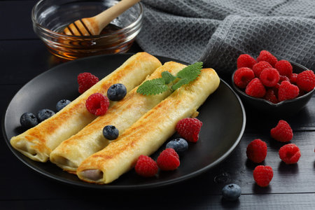 Pancakes rolls with honey and berries.の写真素材