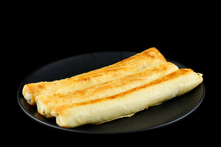 Pancake rolls on a black plate.の写真素材