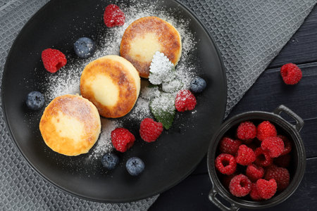 curd fritter with berries in a plate. cottage cheese fritters.の写真素材