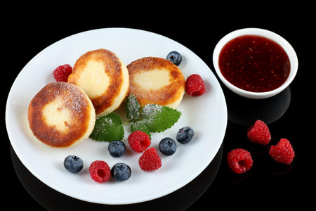 Cottage cheese fritters in a plate with berries.の写真素材