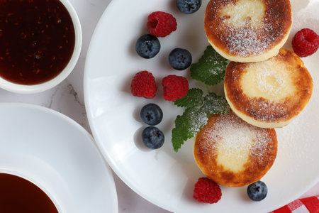 Cottage cheese fritters in a plate with berries.の写真素材