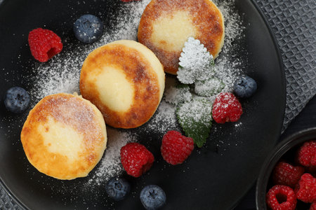 curd fritter with berries in a plate. cottage cheese fritters.の写真素材
