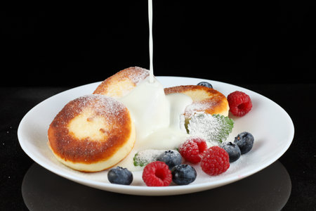 Cottage cheese fritters with yogurt or creamの写真素材