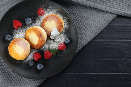 Cottage cheese fritters in a plate with berries.の写真素材