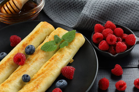 Pancakes rolls with raspberries and blueberries. Traditional breakfast and food.の写真素材