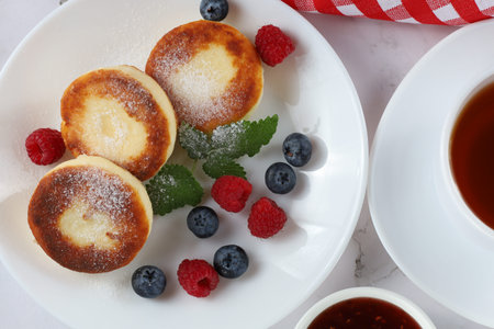 curd fritter with berries in a plate. cottage cheese fritters.の写真素材