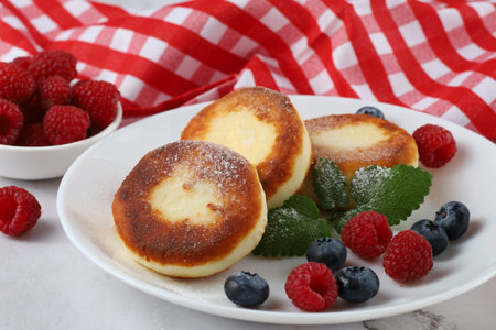 curd fritter with berries in a plate. cottage cheese fritters.の写真素材
