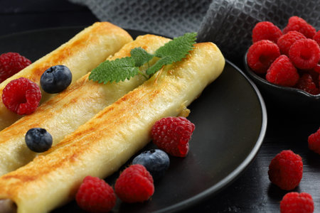 Pancakes rolls with raspberries and blueberries. Traditional breakfast and food.の写真素材