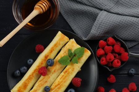 Pancakes rolls with honey and berries.の写真素材