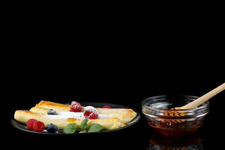 Pancakes rolls with honey and berries.の写真素材