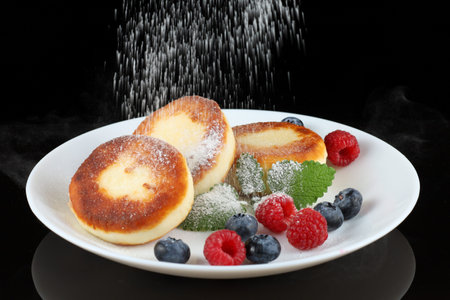 Cottage cheese fritters in a plate with berries.の写真素材