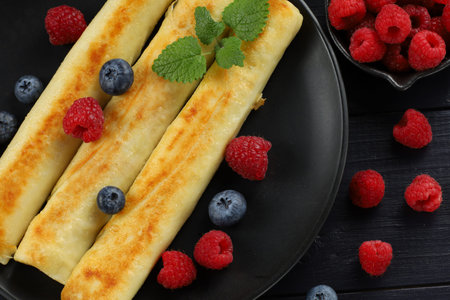 Delicious and traditional food in Ukraine. Pancakes rolls with raspberries and blueberries.の写真素材