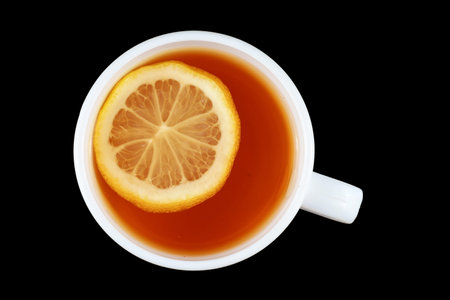 Tea with lemon in a white cup. tea on a black backgroundの写真素材