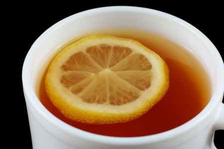 Tea with lemon in a white cup. tea on a black backgroundの写真素材