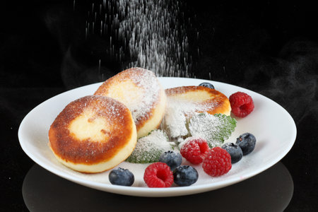 Cottage cheese fritters in a plate with berries.の写真素材