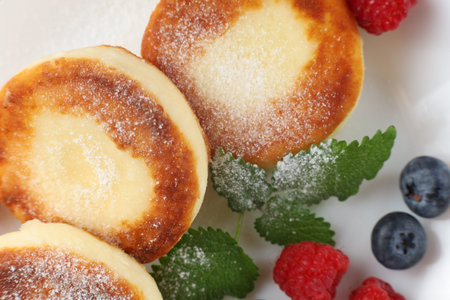 curd fritter with berries in a plate. cottage cheese fritters.の写真素材
