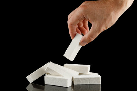 lozenge in hand. A hand takes a white vanilla pastille sweet.の写真素材