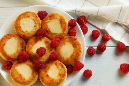 curd fritters on a plate with raspberries. Delicious homemade food.の写真素材