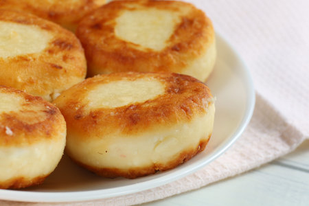 curd fritters on a white plate. A light and tasty breakfast. Photo in light style.の写真素材