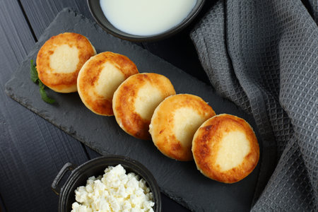 curd fritters with milk and cottage cheese. Food photo in a dark tone.の写真素材