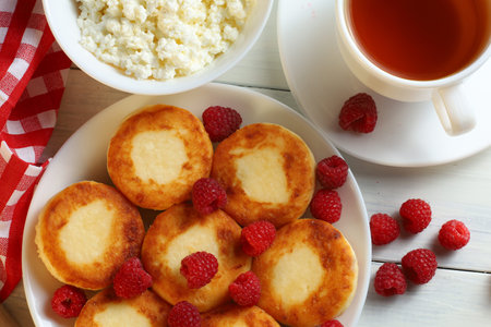 curd fritters with raspberries Traditional breakfast. Food on a bright table.の写真素材