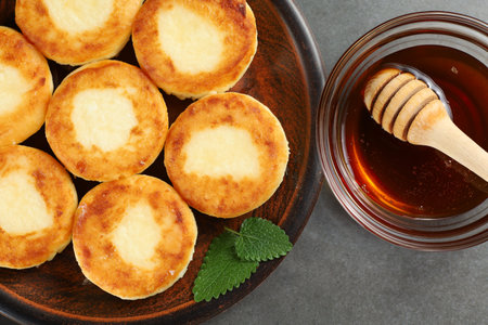 curd fritters with honey. Traditional hearty and tasty breakfast.の写真素材