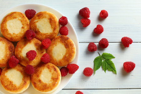 curd fritters and raspberries. Cheese fritters, pancakes or syrnikiの写真素材