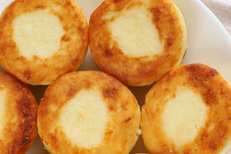 curd fritters on a white plate. A light and tasty breakfast. Photo in light style.の写真素材
