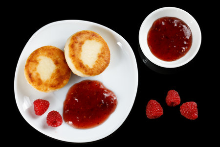 curd fritters in a plate with raspberry jam. Fried Cottage cheese pancake with raspberry jamの写真素材