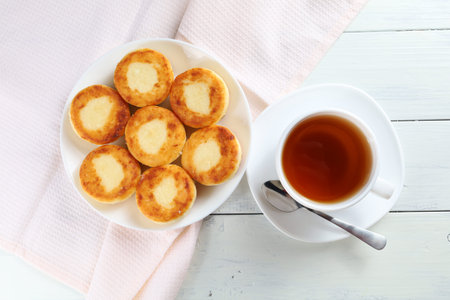 curd fritters with tea. traditional breakfast. Food on a bright table.の写真素材