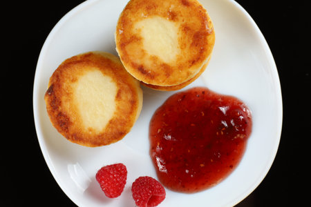 curd fritters in a plate with raspberry jam.の写真素材